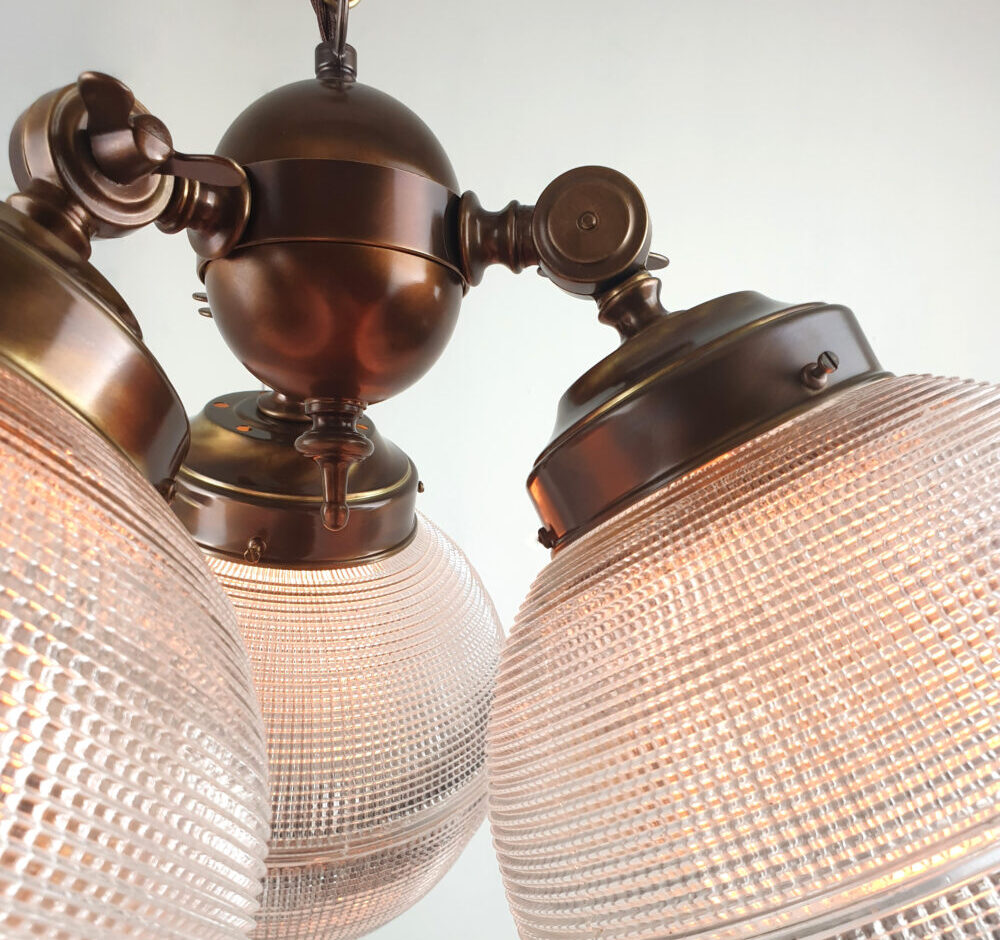 three arm brass chandelier with holophane glass globes detail